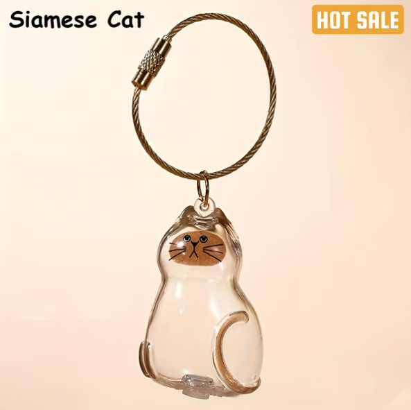 Pet Hair Memorial Capsule Keychain by CC+Tea featuring a clear capsule with pet hair inside and a keyring attachment.