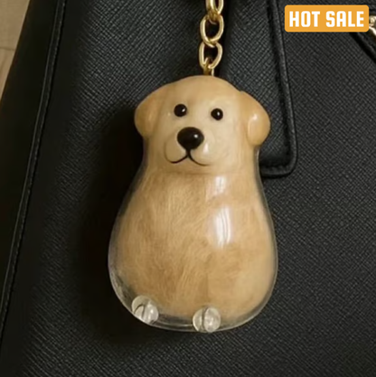 Pet Hair Memorial Capsule Keychain by CC+Tea showing a small clear capsule with pet hair inside and a keyring attachment.