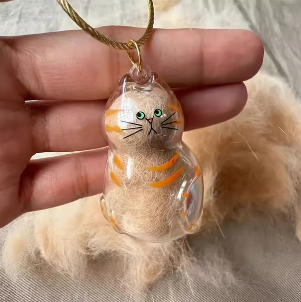 Pet Hair Memorial Capsule Keychain by CC+Tea, featuring a small transparent capsule with pet hair inside and a keyring attachment.